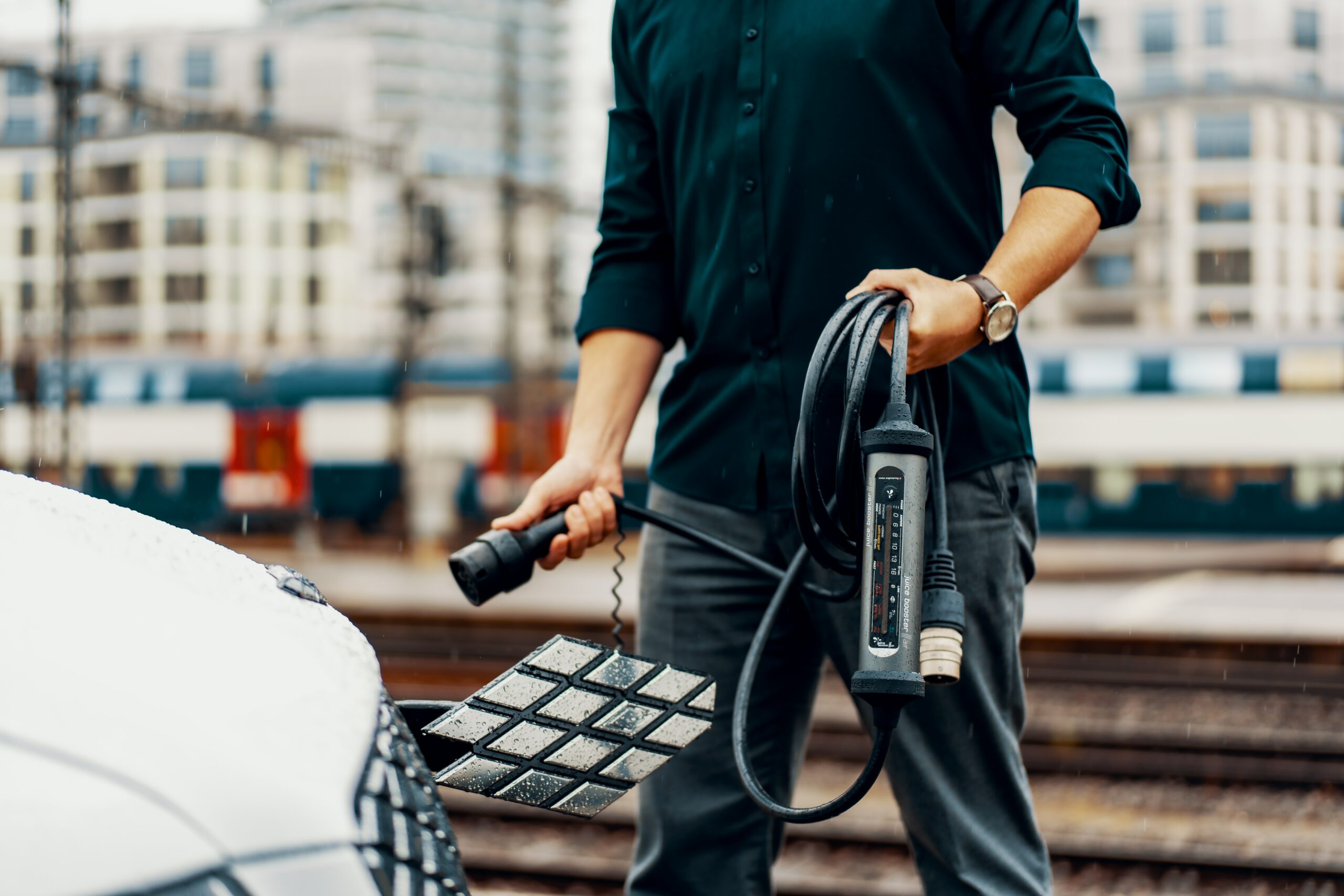 A man is charging his car with a cord using a lease or novated lease.