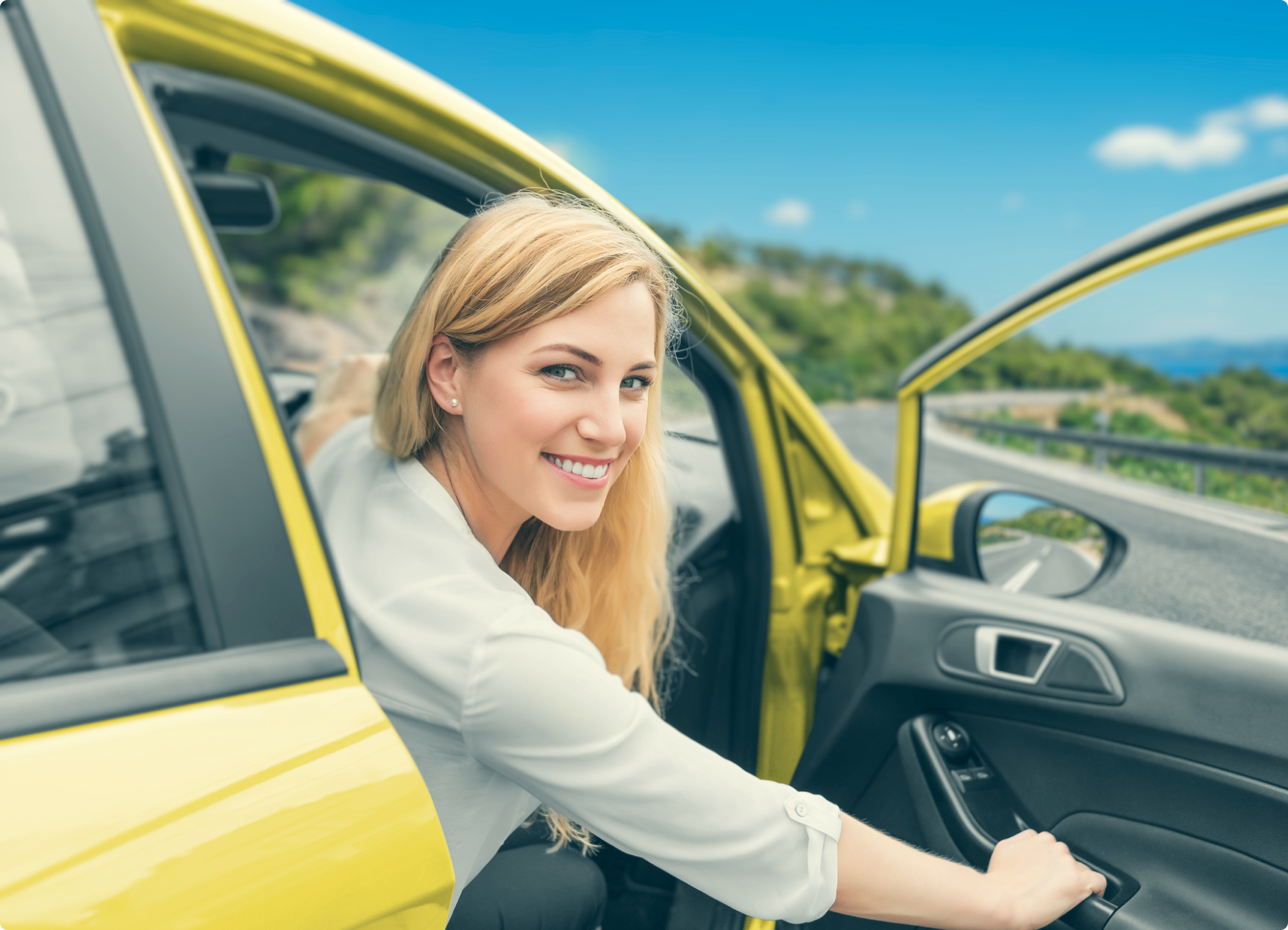 A woman sitting in the driver's seat of a yellow car, potentially considering a novated lease.