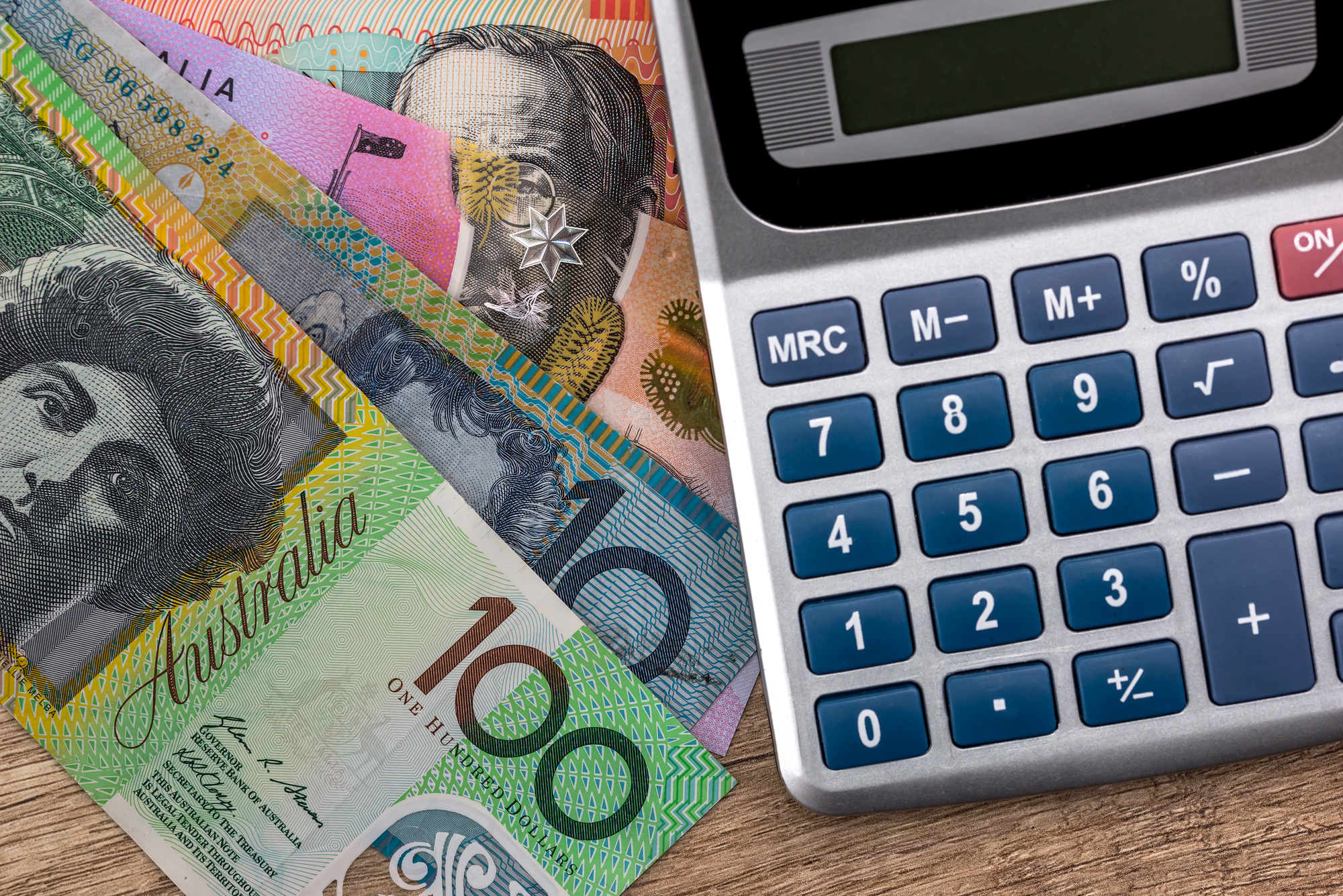 A novated lease calculator sits on top of a stack of australian dollars.
