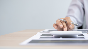 Man calculating salary sacrificing at desk with a calculator and paperwork